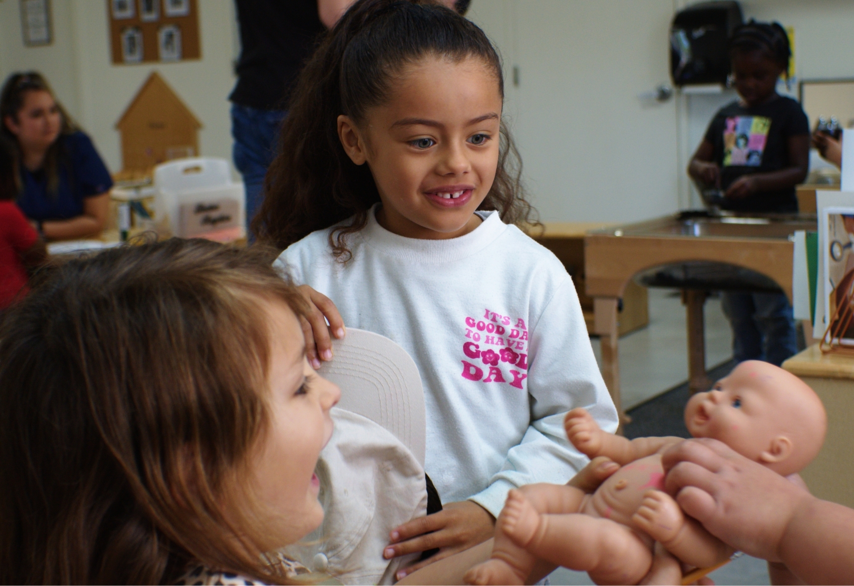 Children holding a toy baby